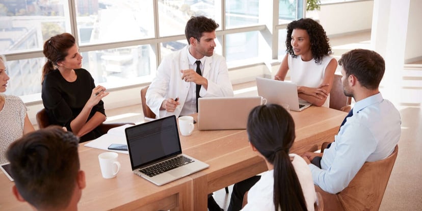 A group of health care administrators conducting a meeting in a conference room. 